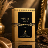 Soghaat Maison Alhambra Your Touch Oud Eau de Parfum 100ml bottle in a gold and black box on a dark marble surface.