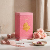 Soghaat Zimaya Ode To Rose Royale perfume box in pink with gold rose emblem, displayed with fresh pink roses.